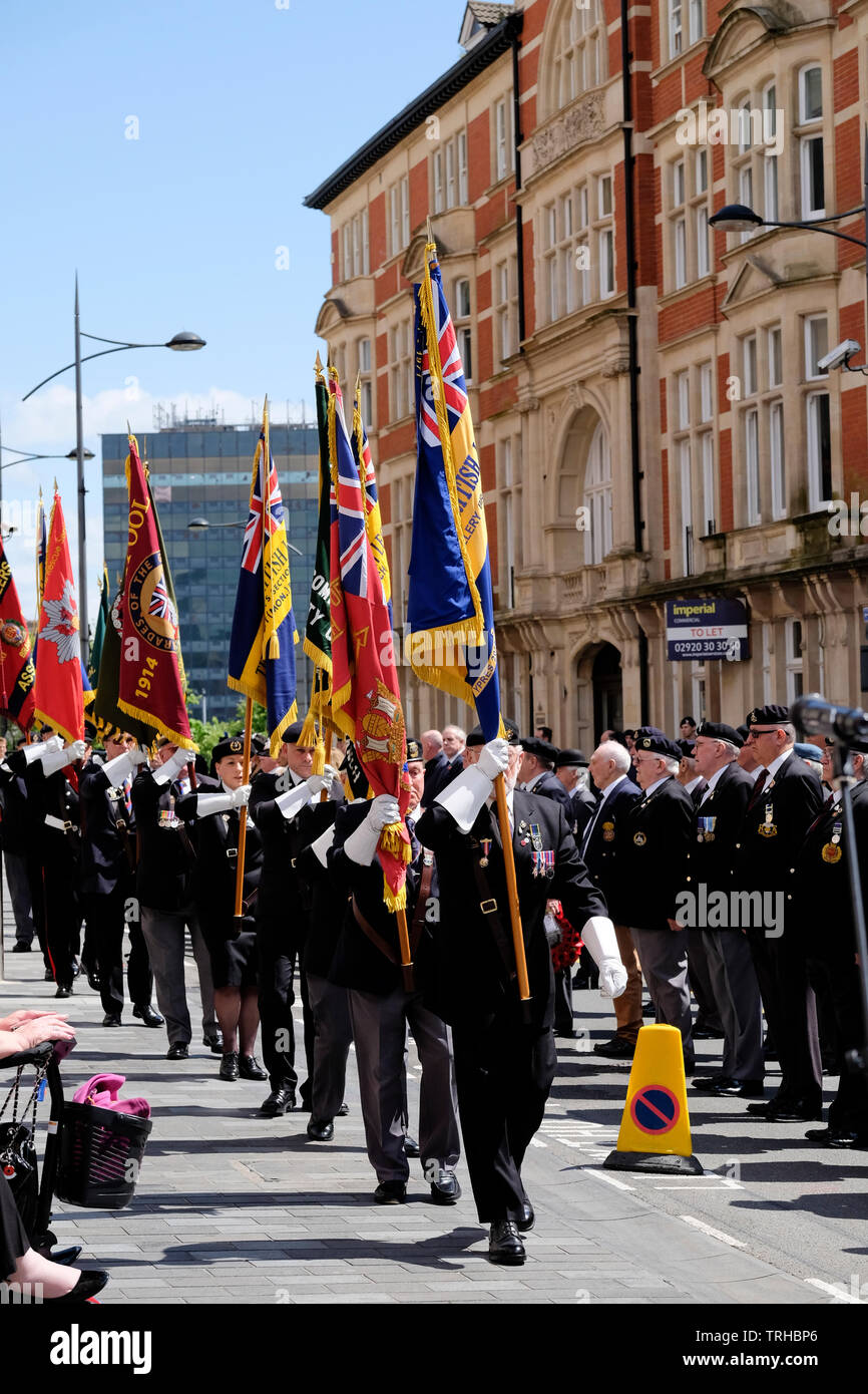 Newport, Wales, UK, 6th June 2019. Cadets, current and former servicemen parade through the city to commemorate the 75th anniversary of the D-Day invasion. The annual parade is organised by the Royal Welsh Comrades Association. Banners were held proudly aloft, and medals worn as they marched to the D-Day memorial. Newport’s memorial commemorates the men of the 2nd Battalion Welsh Borderers who landed on Gold Beach Normandy.  Credit: Mr Standfast/Alamy Live News Stock Photo