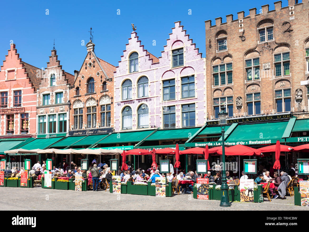 Old buildings now cafes and restaurants with ornate gables in the Historic square the Markt in the centre of Bruges Belgium West Flanders EU Europe Stock Photo