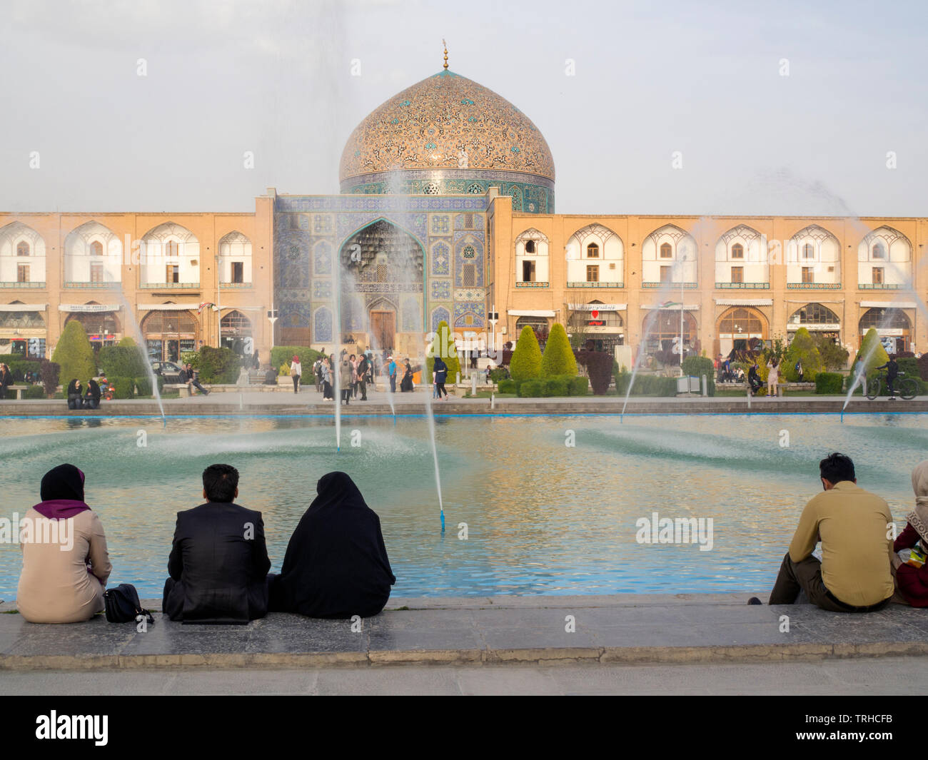 People watching the sun set over Lotfollah Mosque at Maydan-e Imam Square, also known as Naqsh-e Jahan Square, in Esfahan, Iran. It is a UNESCO World Stock Photo