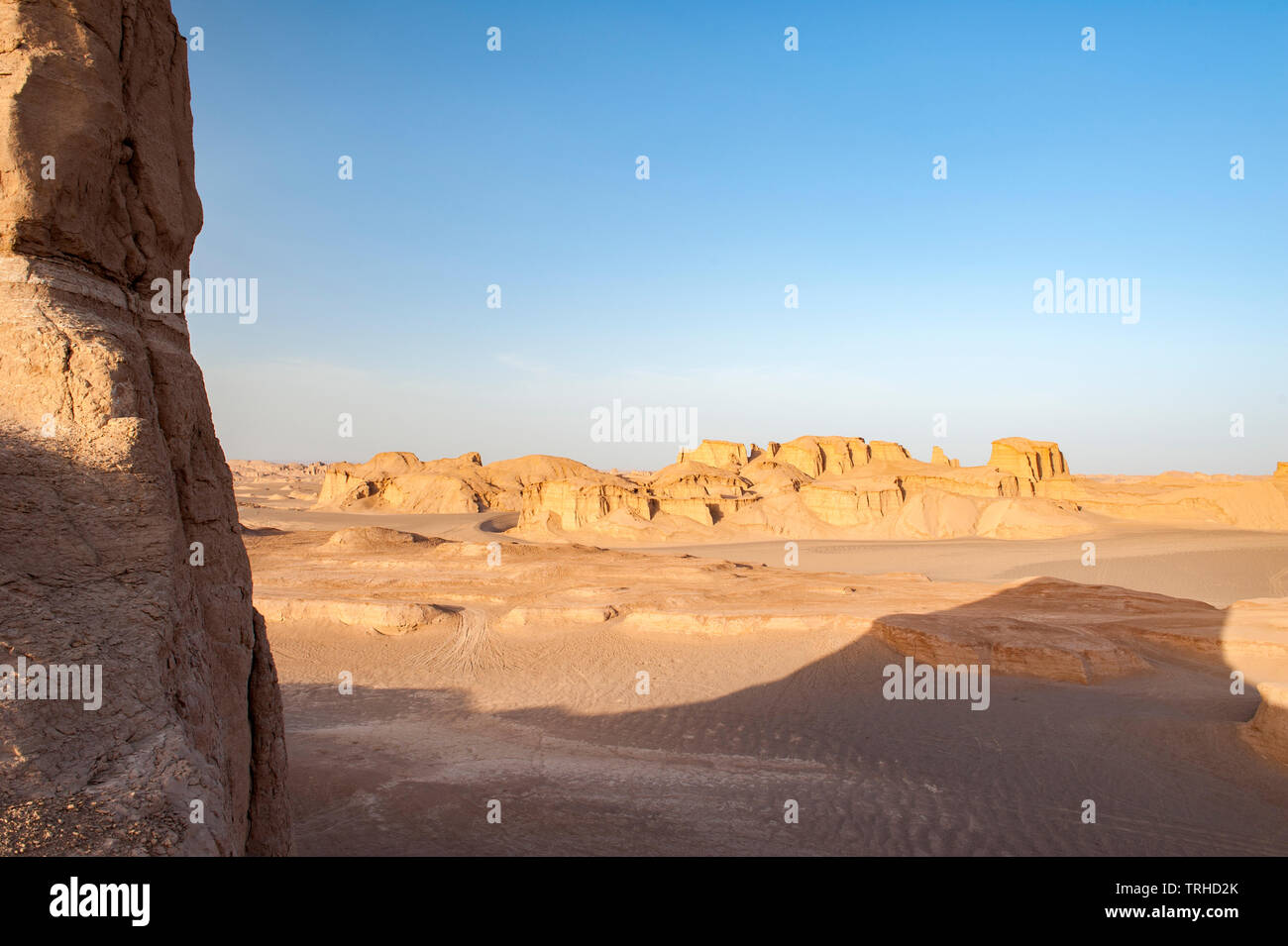 The sun setting over yardangs in the Lut Desert in Shahad, Iran. Known as kaluts in Iran, yardangs are geological formations that have been created by Stock Photo
