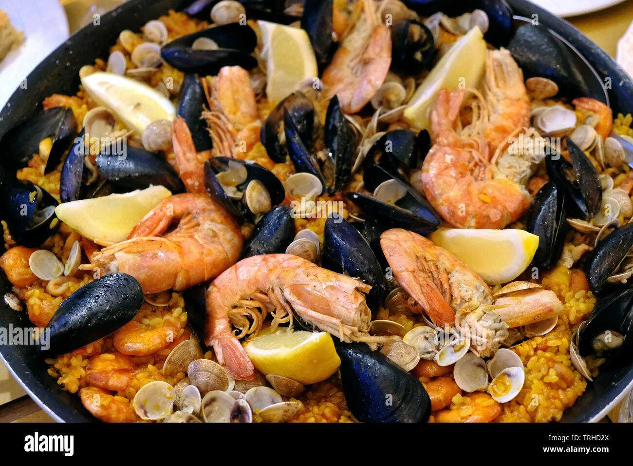 Paella pan with seafood in a restaurant in the coastal town of Fano at night, Marche region, Italy. Stock Photo