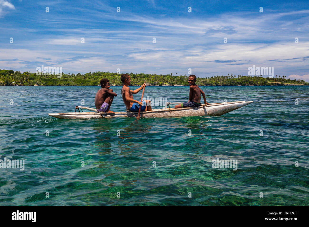 Children in Outrigger Canoe, Tufi, Cape Nelson, Papua New Guinea Stock Photo