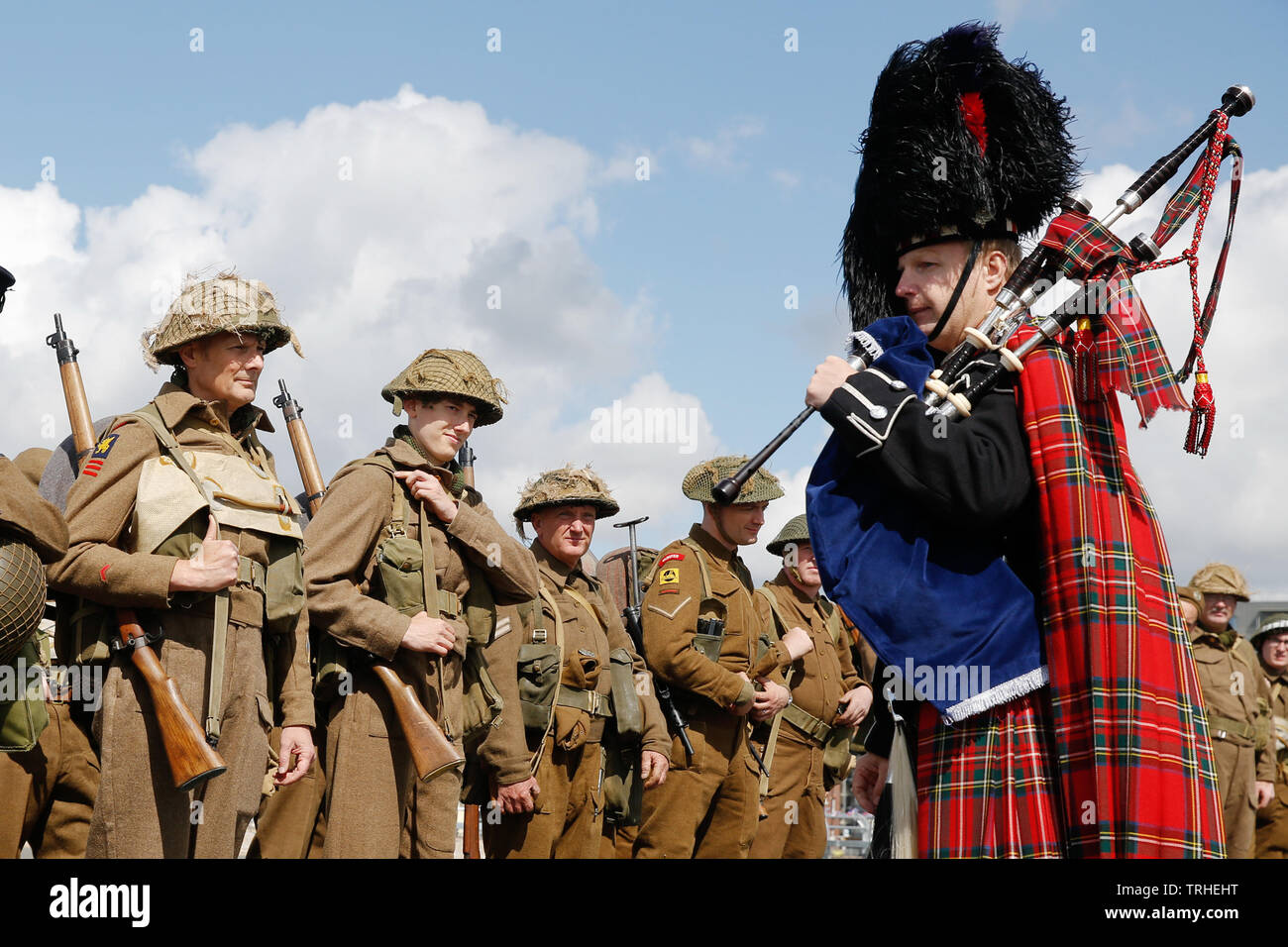 Portsmouth, UK. 6th June, 2019. A piper plays as World War II re-enactors walk the original route the d-day soldiers took through Portsmouth to the landing craft, at South Parade Pier in Southsea, Portmsouth Thursday June 6, 2019. D-day commemorations marking the 75th anniversary of the d-day landings take place this week in the UK and France Photograph : Credit: Luke MacGregor/Alamy Live News Stock Photo