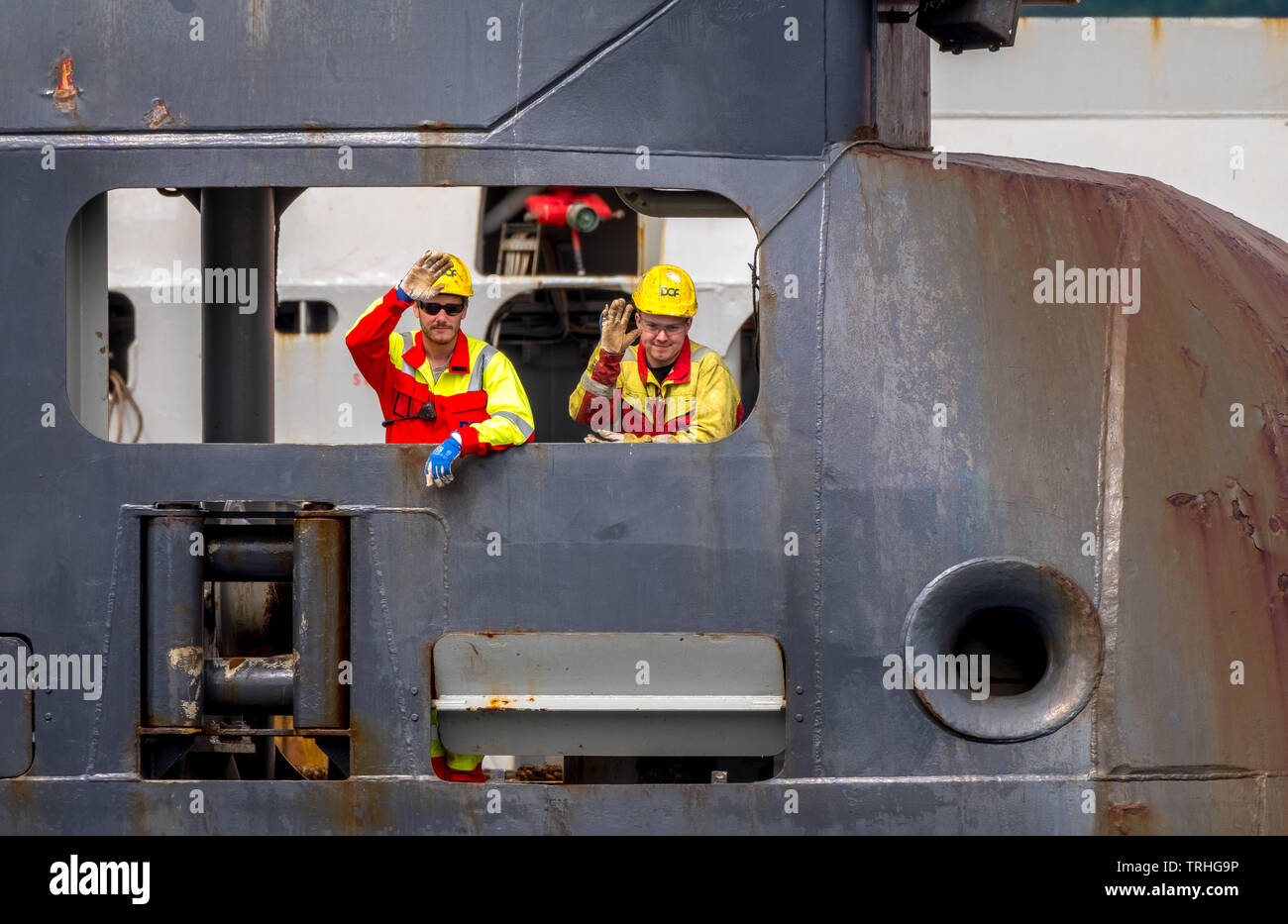 Waving norwegian sailors on an oil rig. Supply ship with safety helmet in Bergen, Hordaland, Norway, Scandinavia, Europe, Bergen, NOR, Travel, Tourism Stock Photo