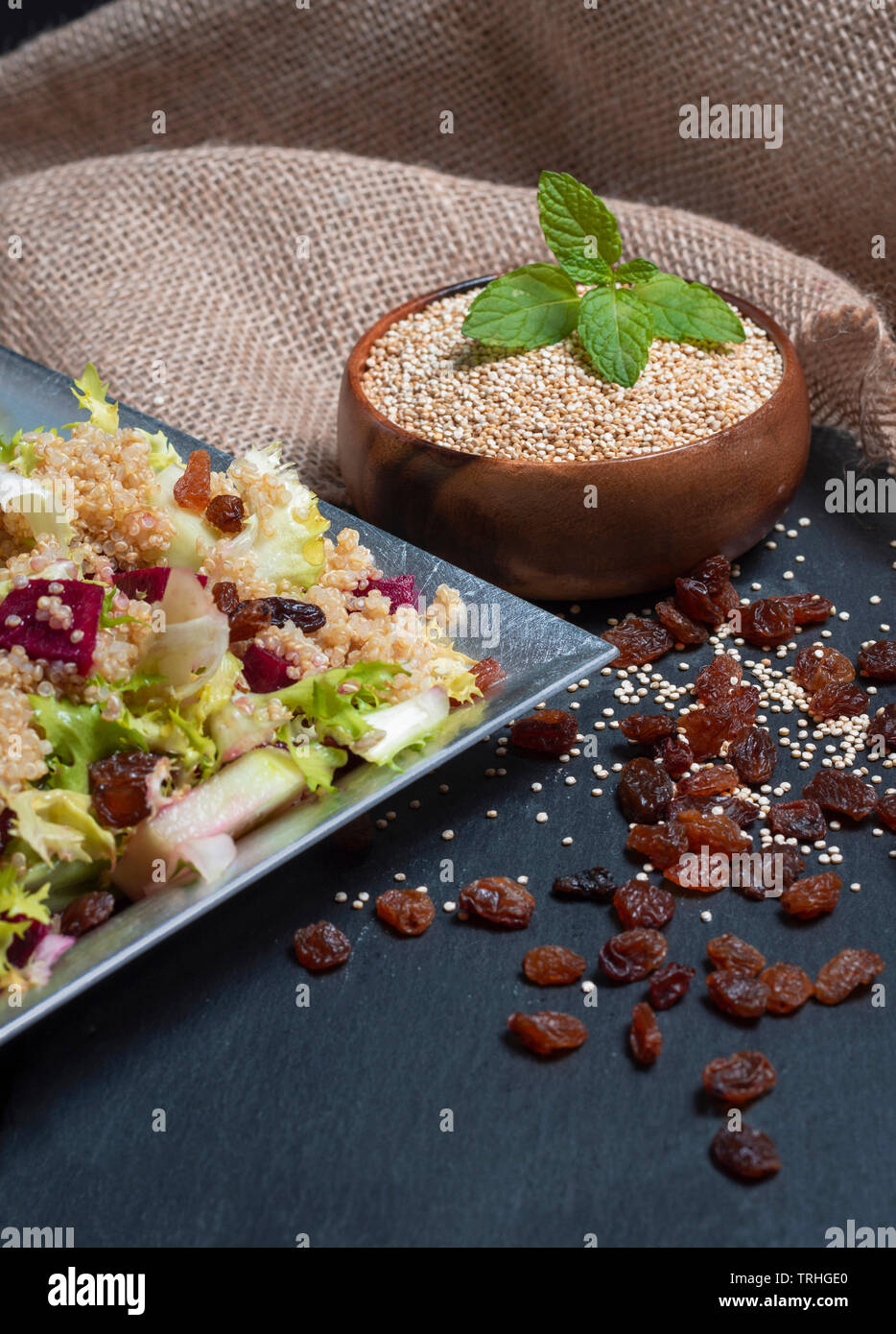 Raw and cooked quinoa served in salad Stock Photo
