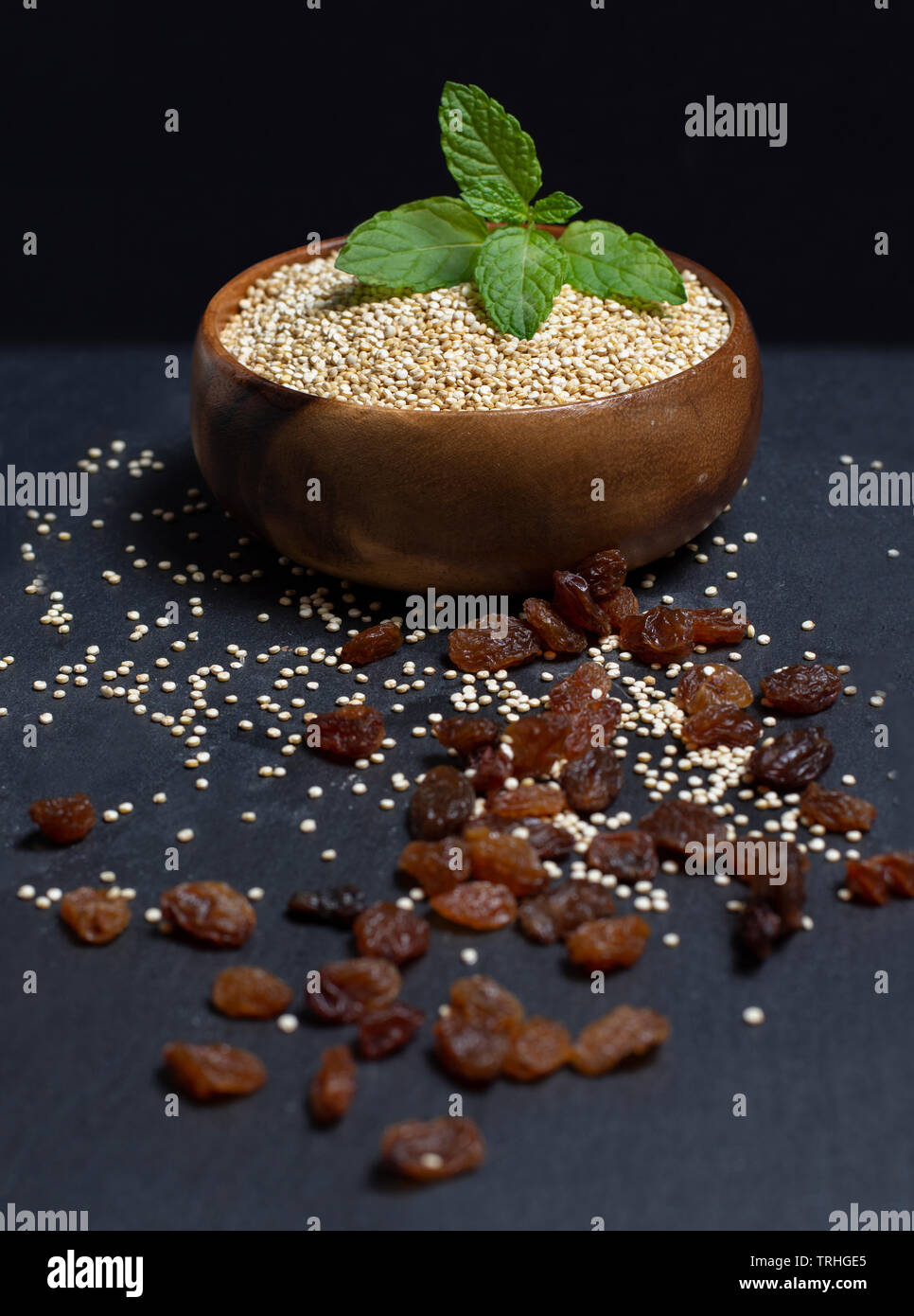 wooden bowl filled with quinoa on black background Stock Photo