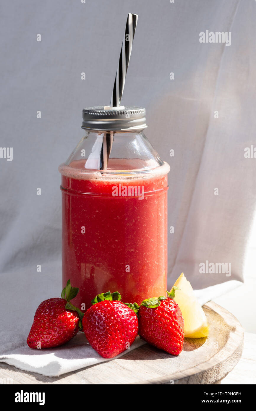 Strawberry juice with light coming through the window and white cloth background Stock Photo