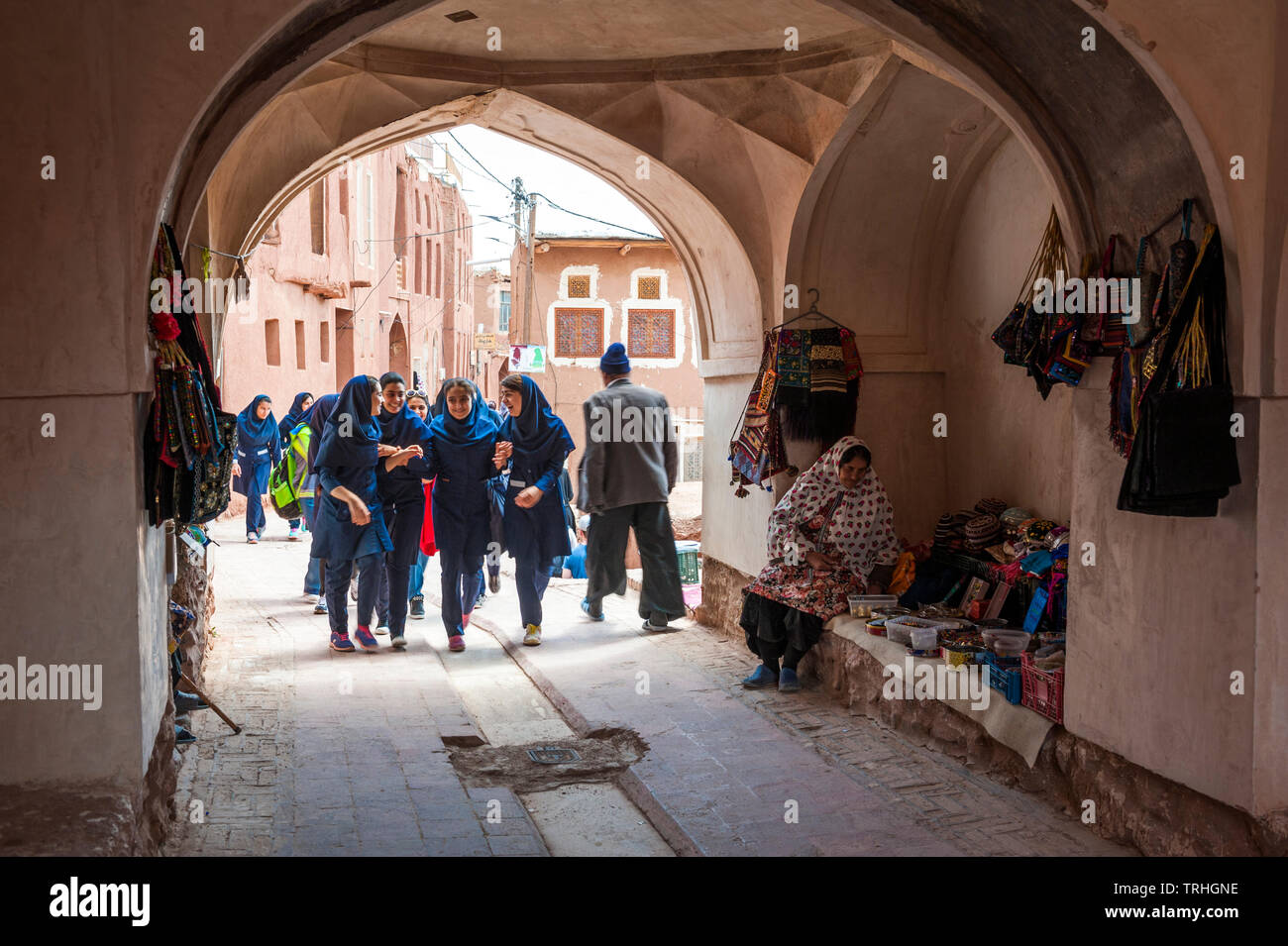 A group of girls walking through an archway in the old town of Abyaneh, Iran. The town is a popular tourist attraction. Stock Photo