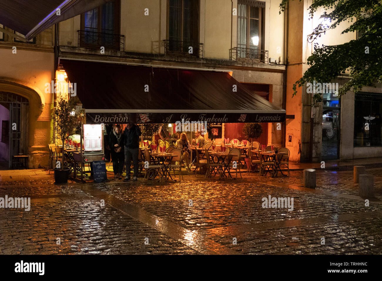 Bouchon in the colorful saint Jean district in old Lyon, France at night in the rain. Bouchon is a-traditional local restaurant in Lyon where you eat Stock Photo
