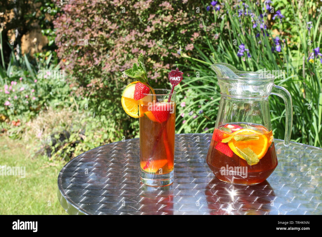 Jug of Pimms and Lemonade outside in sunshine with full glass with copy