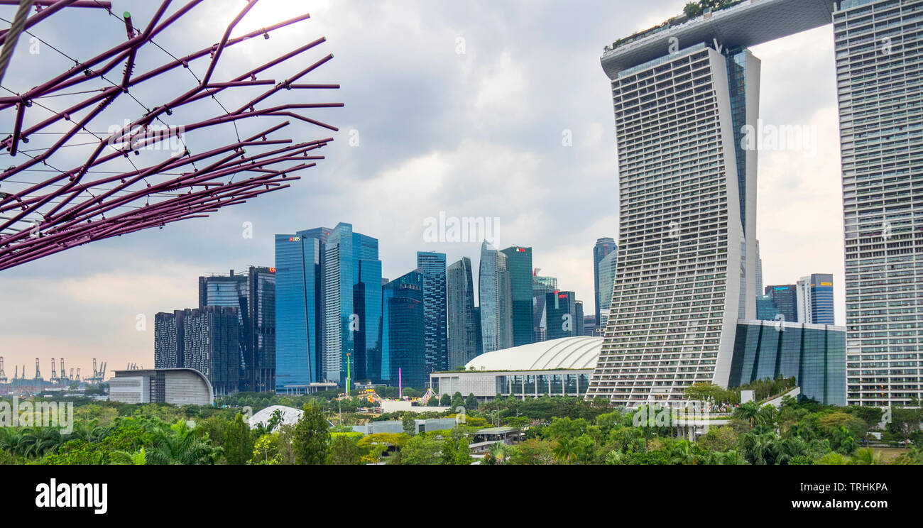 Marina Bay office towers and skyscrapers in downtown Singapore , Marina Bay Sands Resort and steel lattice of a Supertree in the foreground. Stock Photo