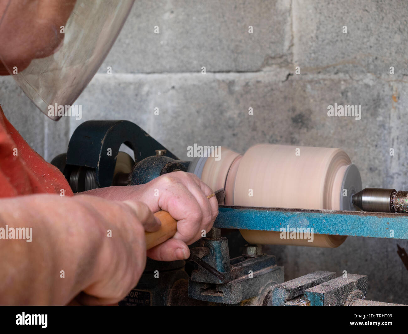 Mature, 65 year old, female crafter turning a wooden vase on her lathe Stock Photo