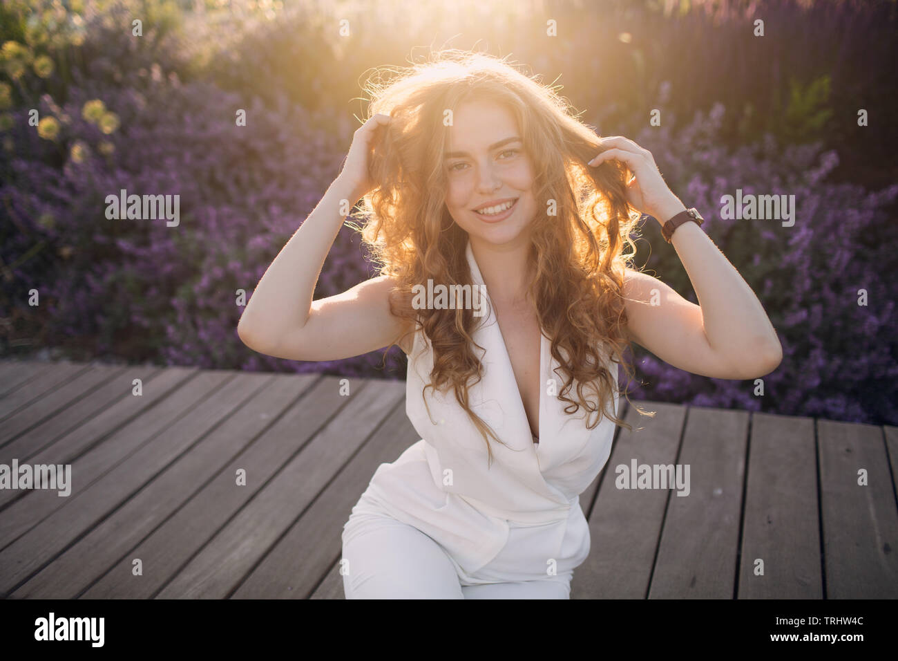 Portrait of young positive woman with curly hair Stock Photo - Alamy