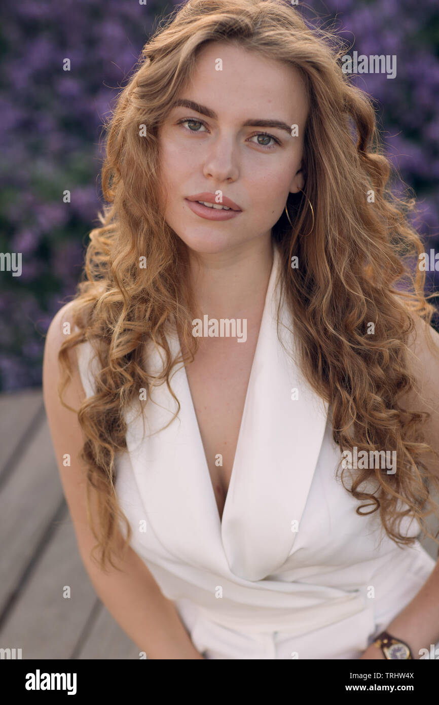 Portrait of young positive woman with curly hair Stock Photo - Alamy