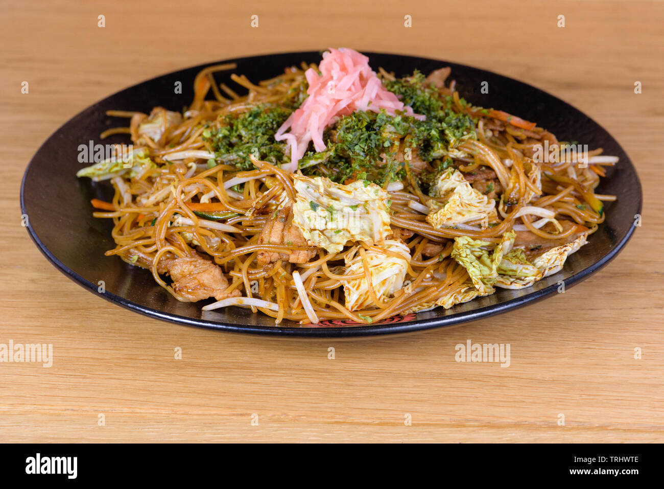 soy spaghetti with chicken and vegetables, decorated with stewed cabbage, pink beetroot and chopped parsley Stock Photo