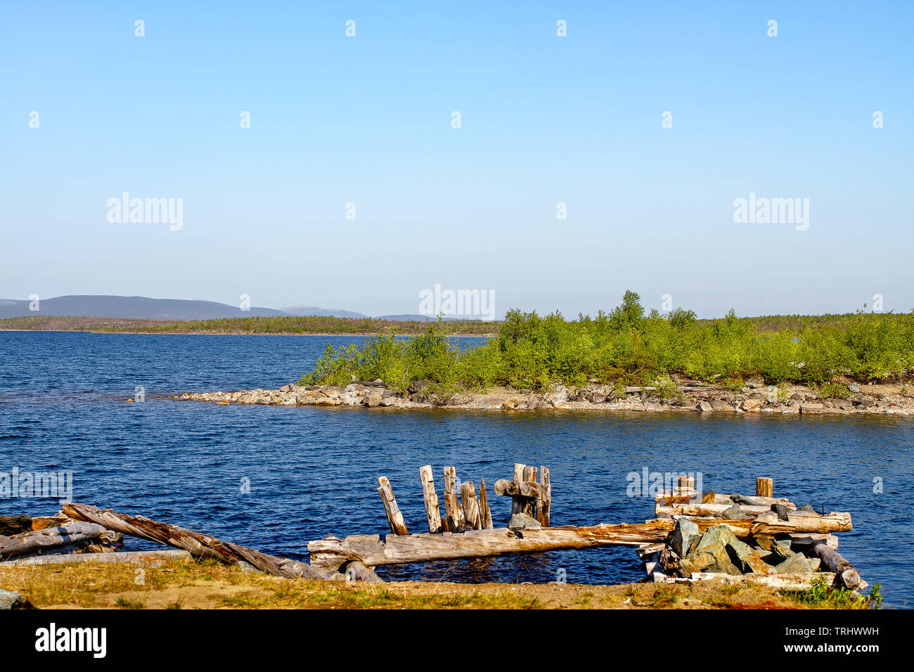 Sea-coast lying logs and mountains on the horizon. Karelia. Russia Stock Photo
