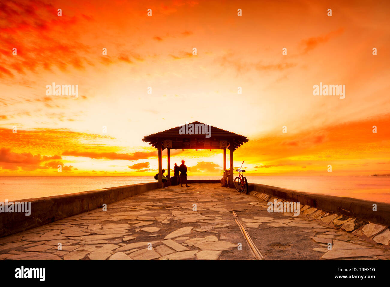 Beautiful golden hour sunset at the walls pier at famous Waikiki Beach in Honolulu, Hawaii Stock Photo