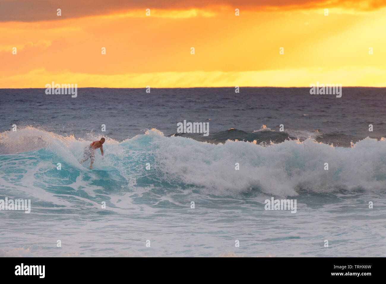 MAKAHA, HAWAII - Anonymous surfer catching a wave on Makaha Beach on January 29, 2015. The beach is reputed to be the birthplace of surfing. Stock Photo