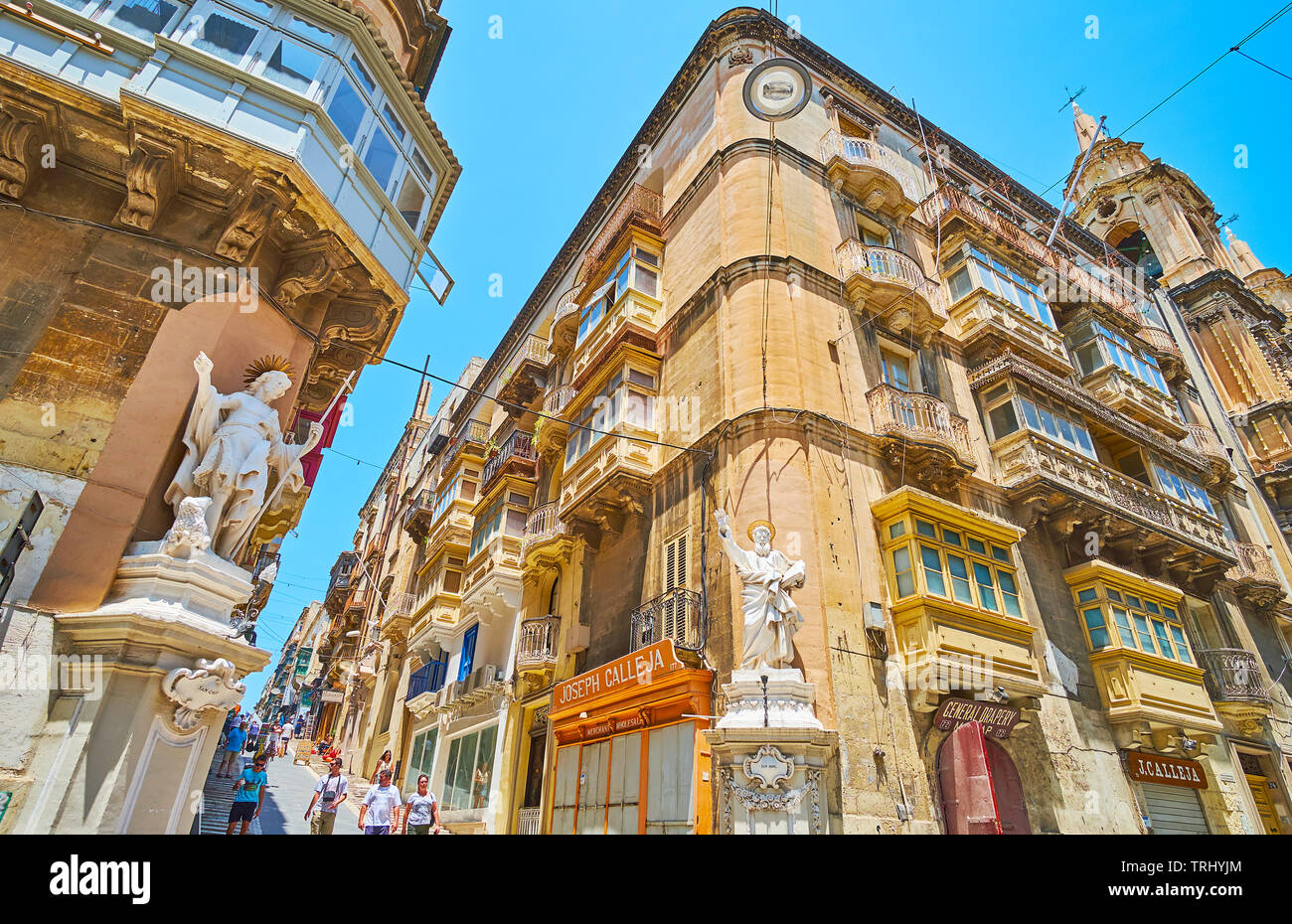 VALLETTA, MALTA - JUNE 19, 2018: The old edifices in St Lucia street are decorated with corner statues of St John and St Paul, on June 19 in Valletta Stock Photo