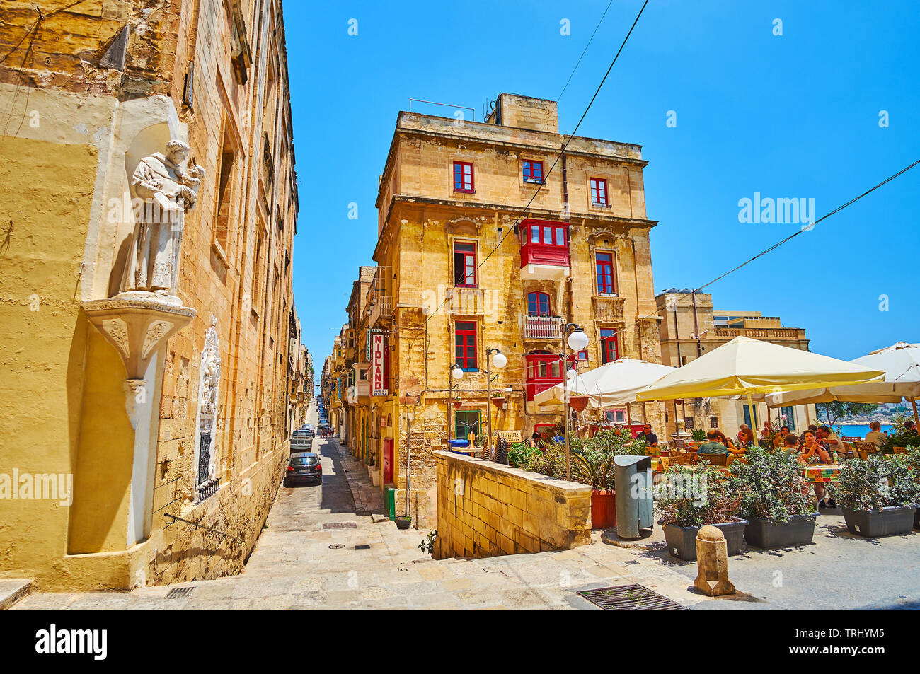 VALLETTA, MALTA - JUNE 19, 2018: St Ursula street is one of the medieval city streets with historical housing, outdoor cafes, wall statues and interes Stock Photo