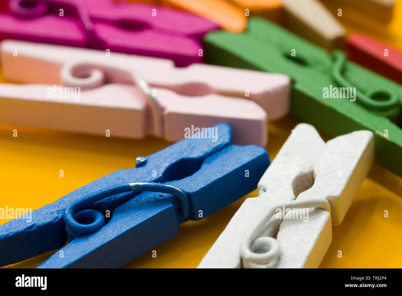 colored clothespins on a yellow background Stock Photo