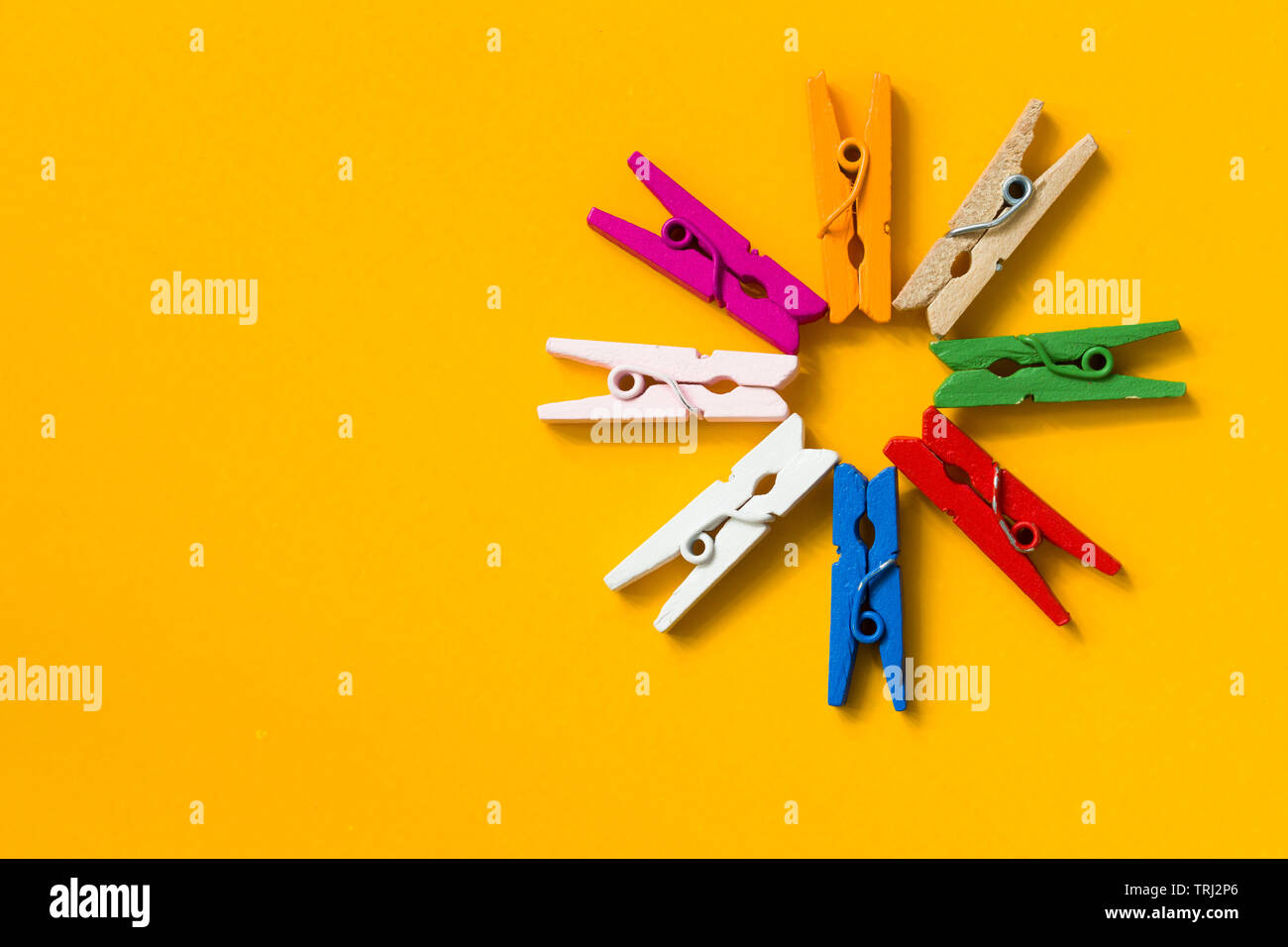 colored clothespins on a yellow background Stock Photo