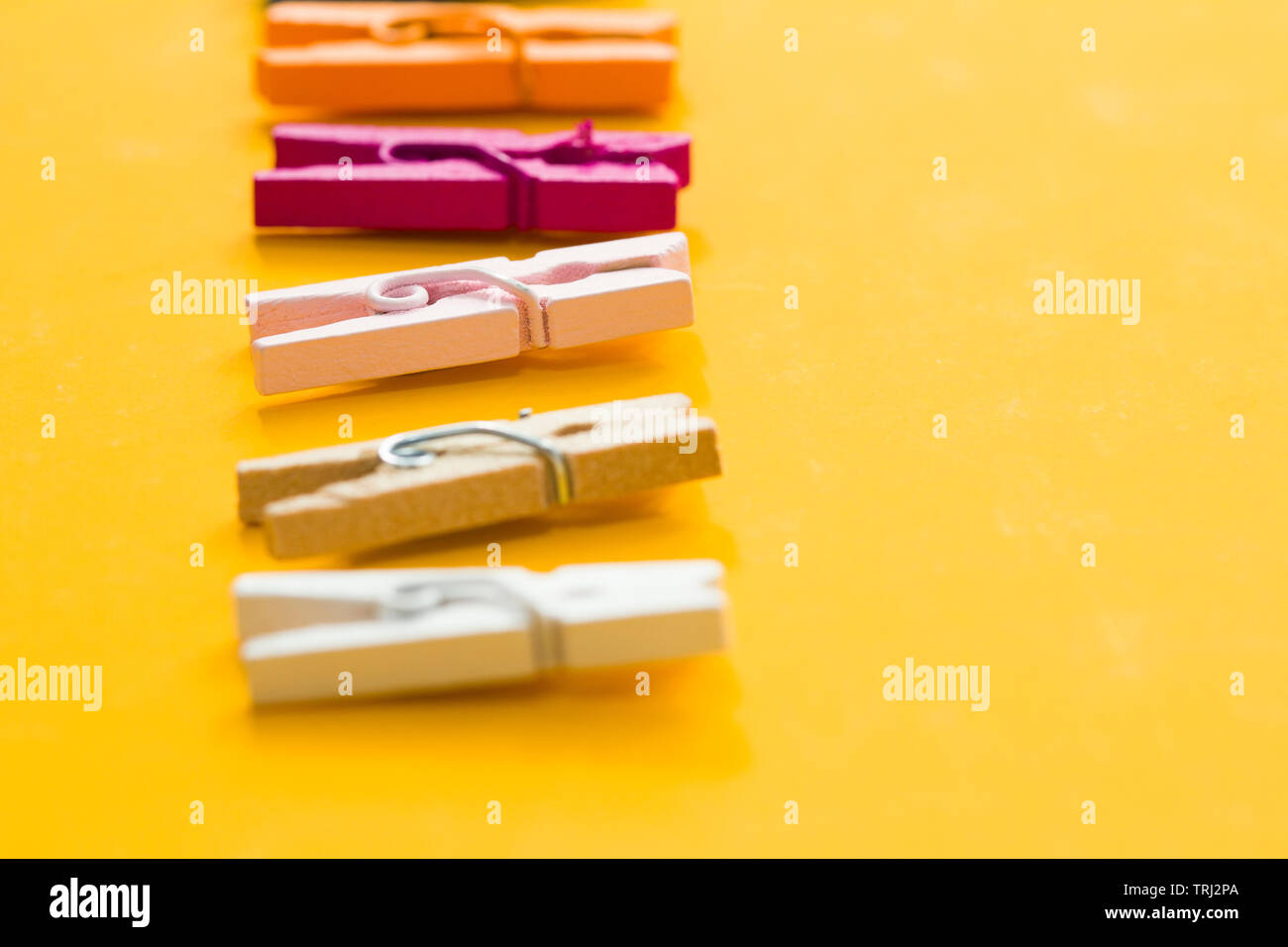 colored clothespins on a yellow background Stock Photo