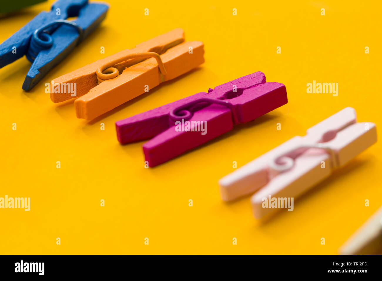 colored clothespins on a yellow background Stock Photo