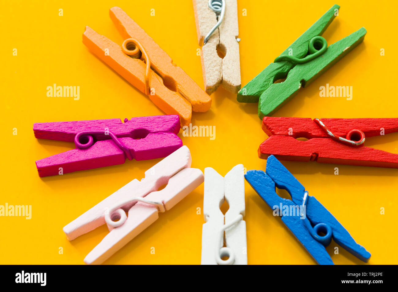 colored clothespins on a yellow background Stock Photo