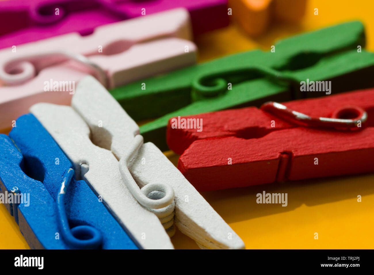 colored clothespins on a yellow background Stock Photo