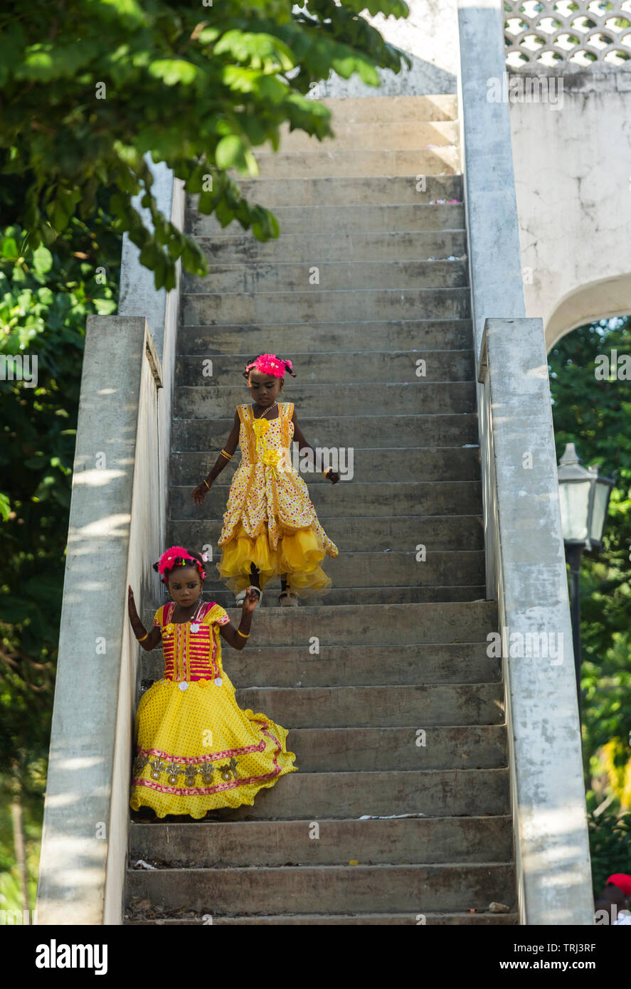 Girls in party dresses running up and down stairs while celebrating Eid in Stonetown, Zanzibar, Tanzania. Stock Photo
