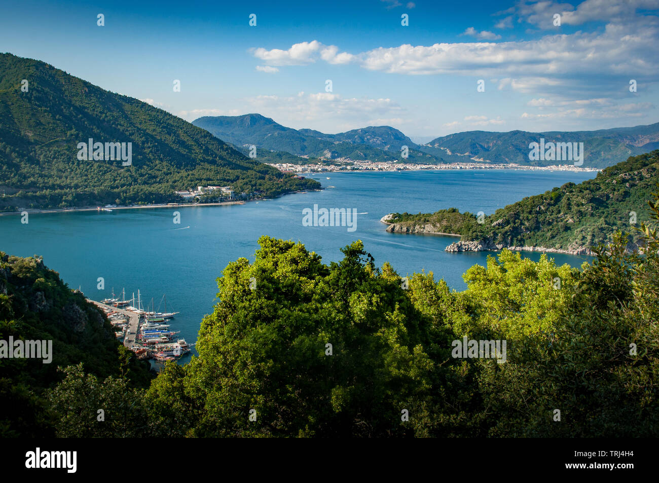 A view from the hills between Turunc and Icmeler, Turkey looking toward Marmaris amid lush pine forested hills and azure blue sea. Stock Photo