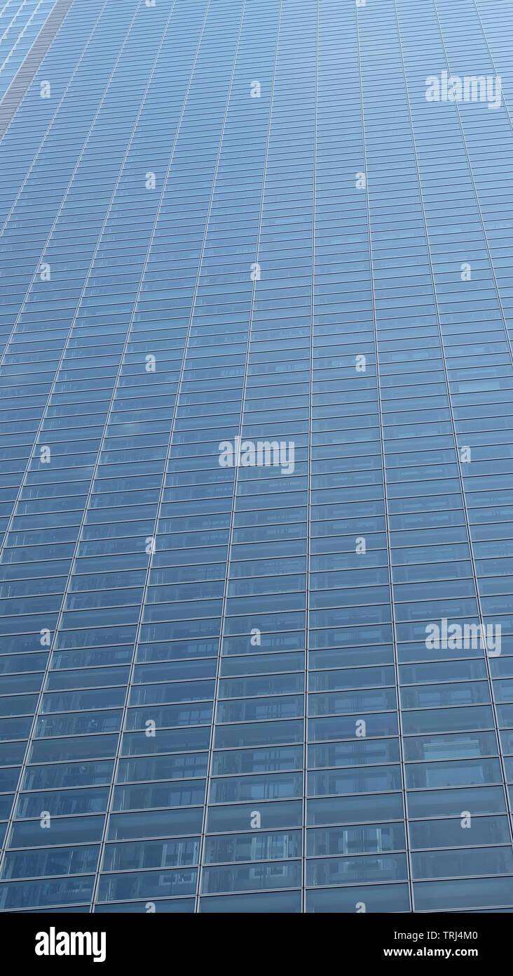 Tall high rise building with with a whole wall of glass window panels ...