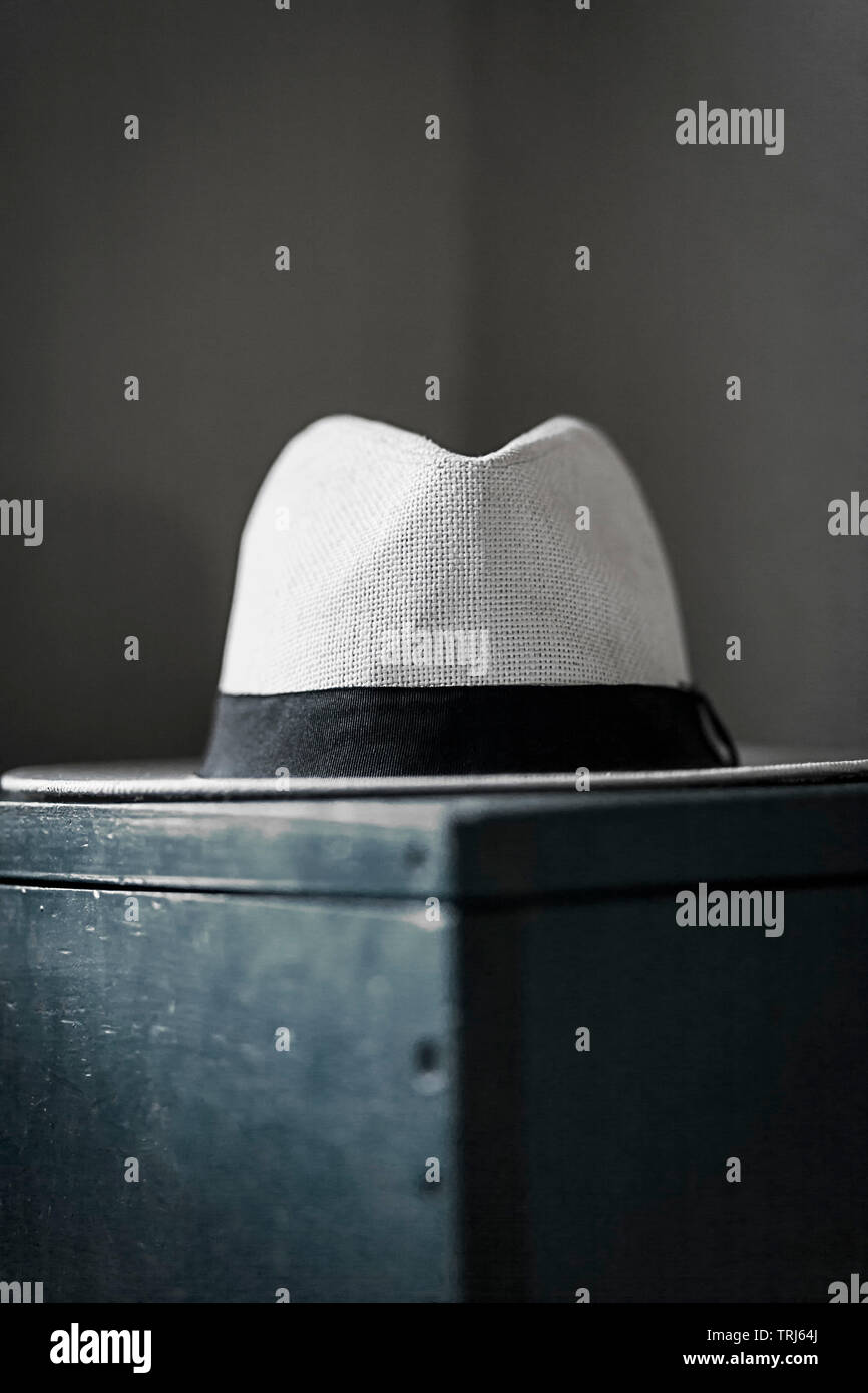 Wide brim panama hat on wooden kist in the corner of a room in the early hours of the morning. Stock Photo