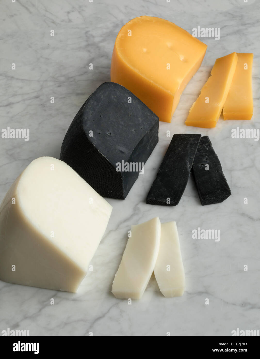 Piece of Dutch white goat cheese, black lemon cheese and Gouda cheese for dessert Stock Photo