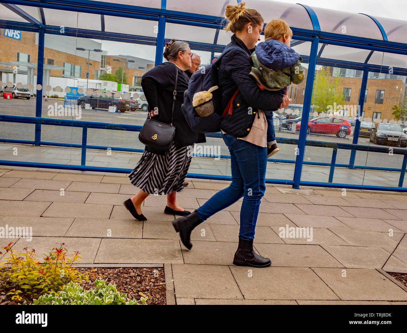 Norwich, Norfolk, UK. 18 May 2019. Candid photos – A mother carrying child outside the NHS Norwich University Hospital Stock Photo