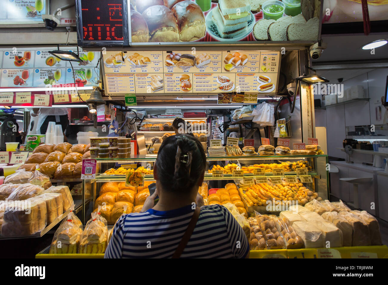 A lady in the middle is buying freshly prepared bread at Bugis street, Singapore. Stock Photo