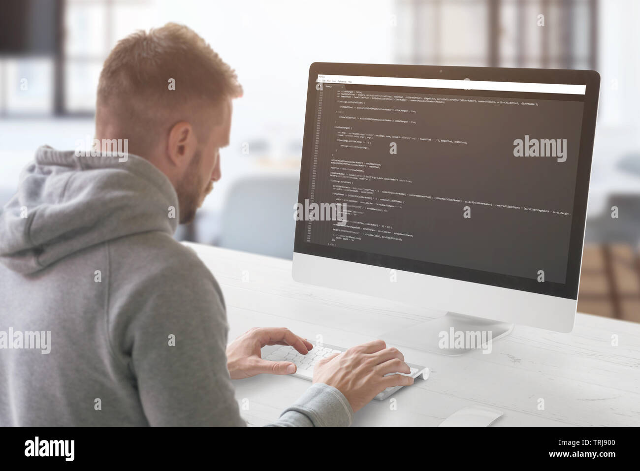 The guy programming on a computer in the office. Stock Photo