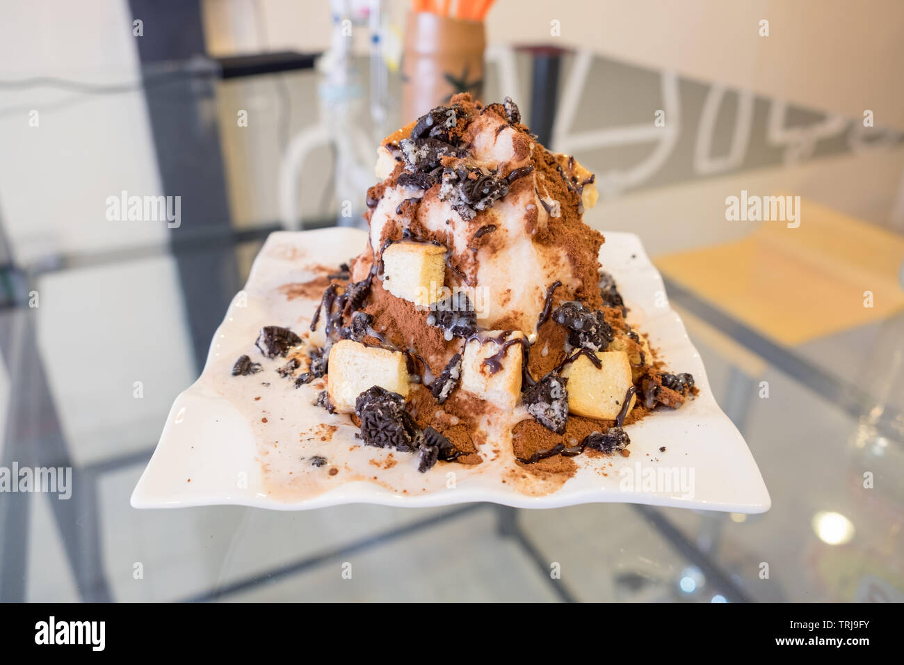 Milk shake pile with chocolate powder and bread on white plate Stock Photo