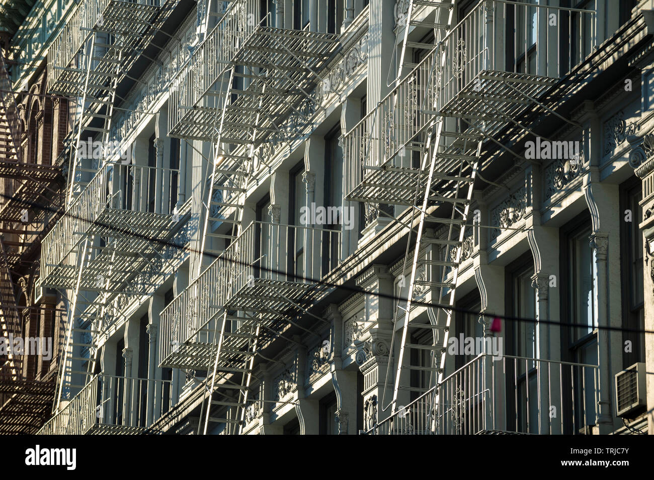 Traditional downtown New York City architecture featuring industrial facades lined with metal fire escapes in the SoHo-Cast Iron Historic District Stock Photo
