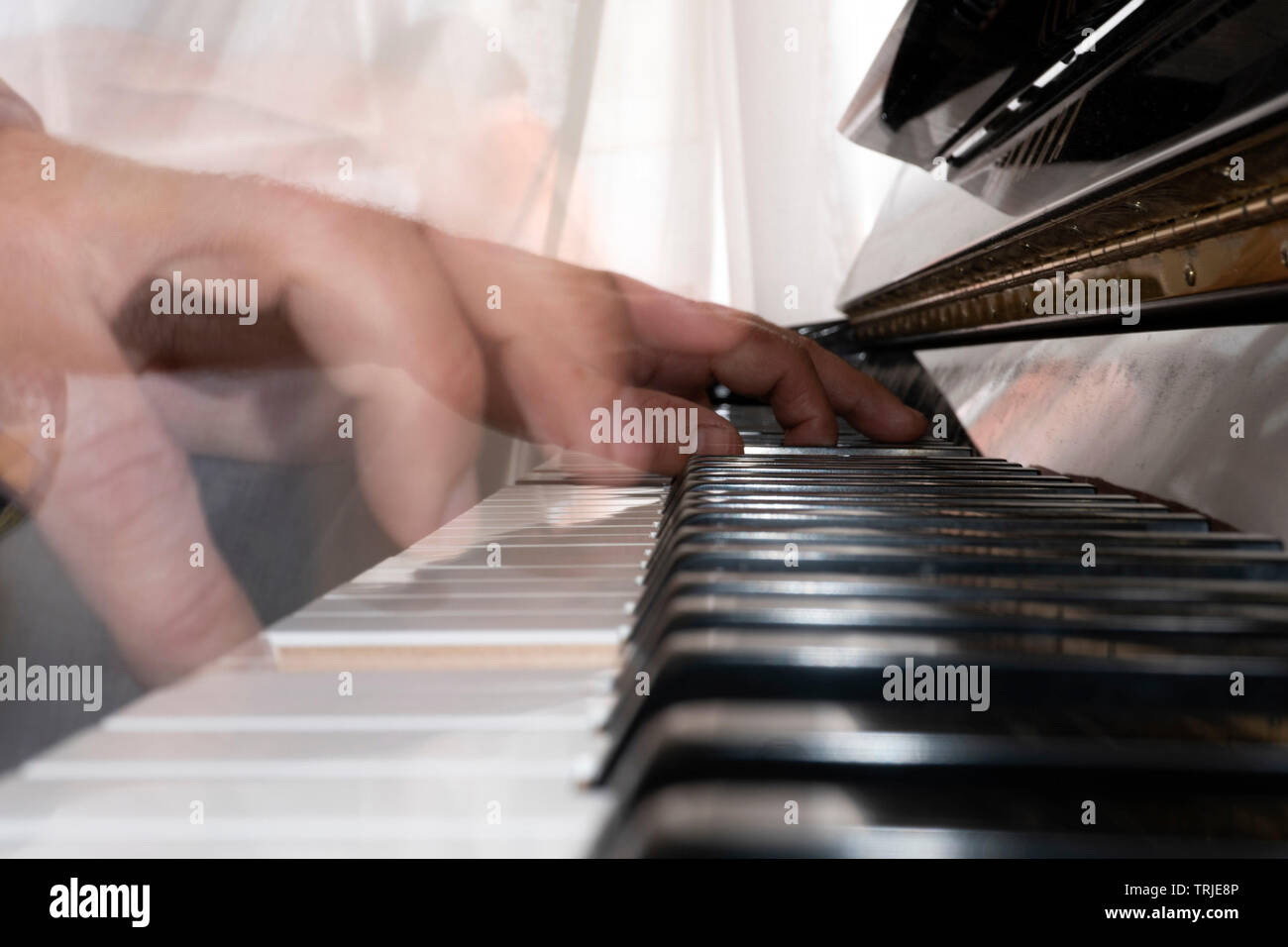Hands playing piano while moving move effect close up Stock Photo - Alamy
