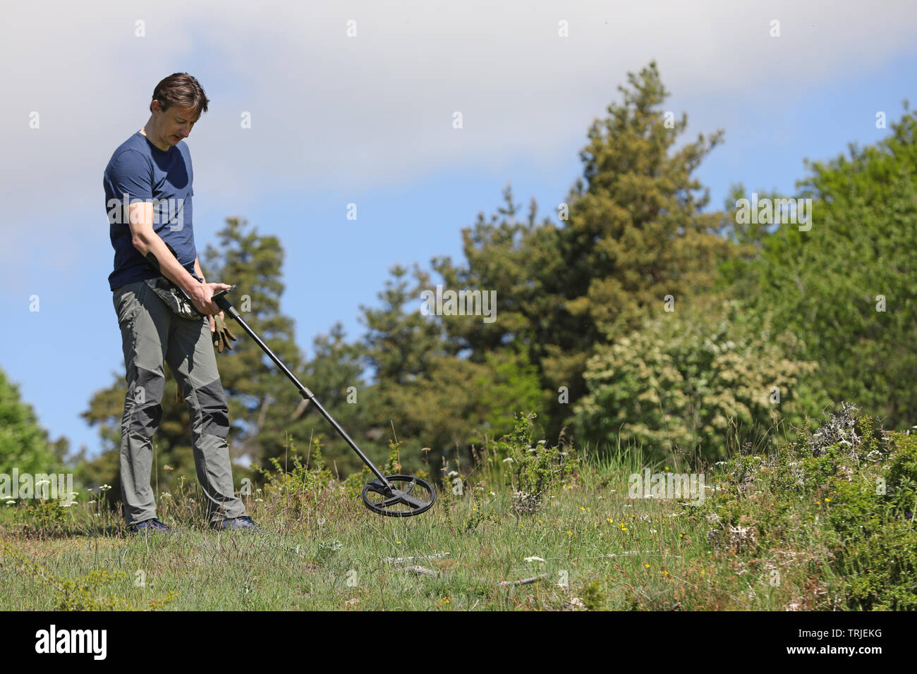 A man searching for buried treasure, ancient coins and historic artefacts with metal detector Stock Photo