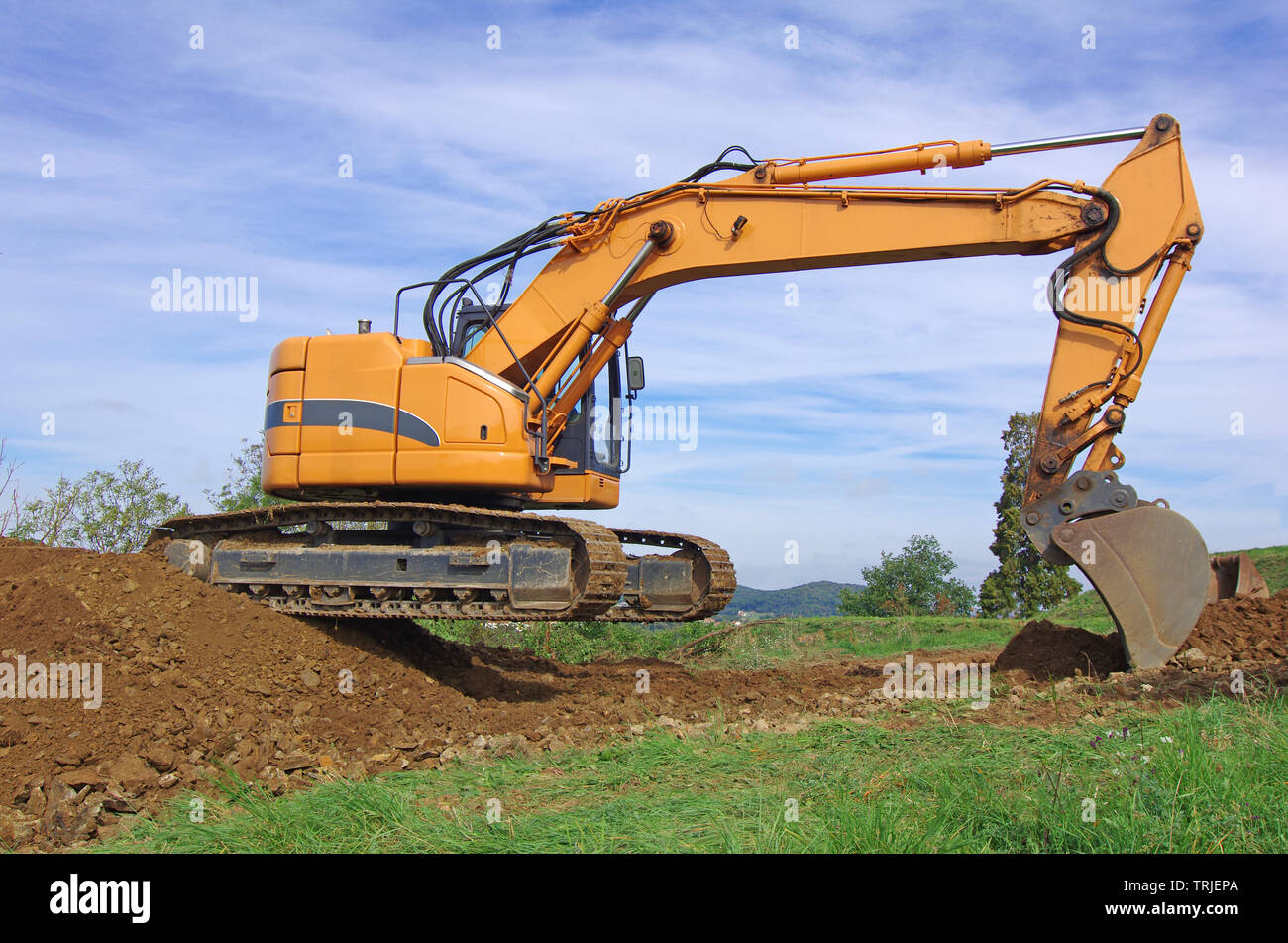 Excavator machine in action during earth moving works. Excavator, earthworks, house construction Stock Photo