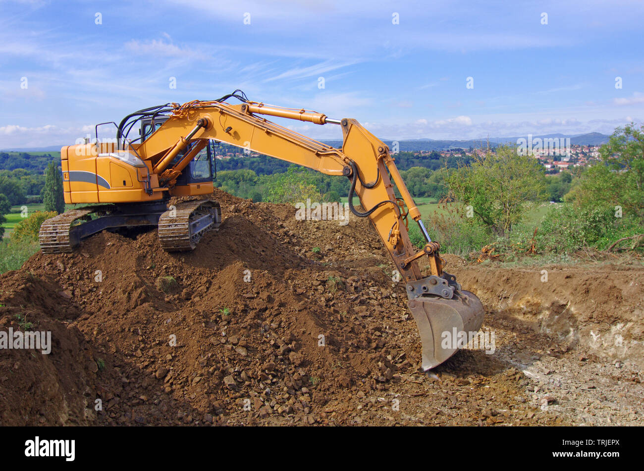 Excavator machine in action during earth moving works. Excavator, earthworks, house construction Stock Photo