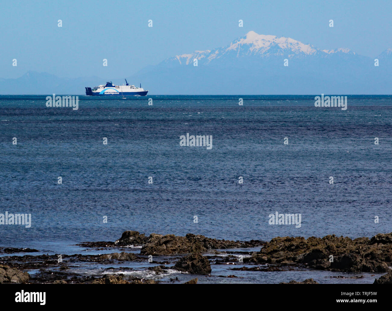 Interislander ferry on the Cook Strait sails towards the South Island. The snow capped mountains can be seen in the background Stock Photo