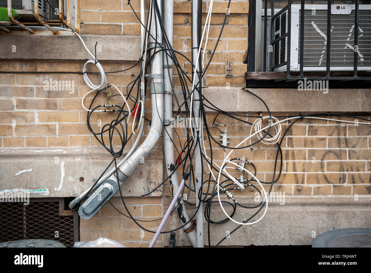 A rat’s nest of wires and cables for telephone, internet and other utilities on the exterior of an apartment building in Brooklyn in New York on Saturday, June 1, 2019.  (© Richard B. Levine) Stock Photo