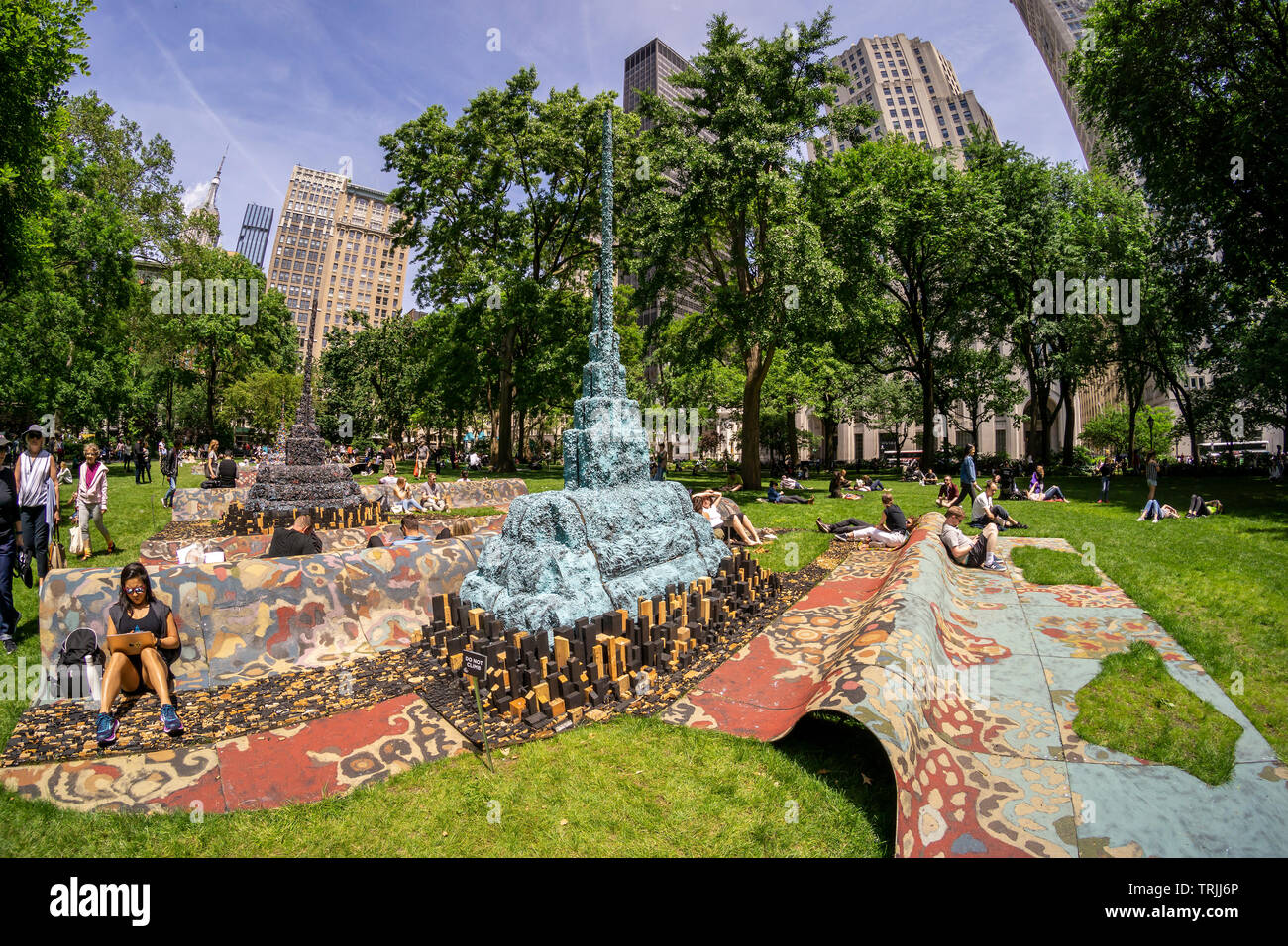 Visitors to Madison Square Park enjoy the warm weather by lounging on the sculpture “City in the Grass” by the artist Leonardo Drew on a warm Tuesday, June 4, 2019. The monumental public art commission presents a stylized cityscape over 100 feet long and provides an experiential activity, relaxing and lounging. The work will be on view and available for seating until December 15, 2019. (© Richard B. Levine) Stock Photo