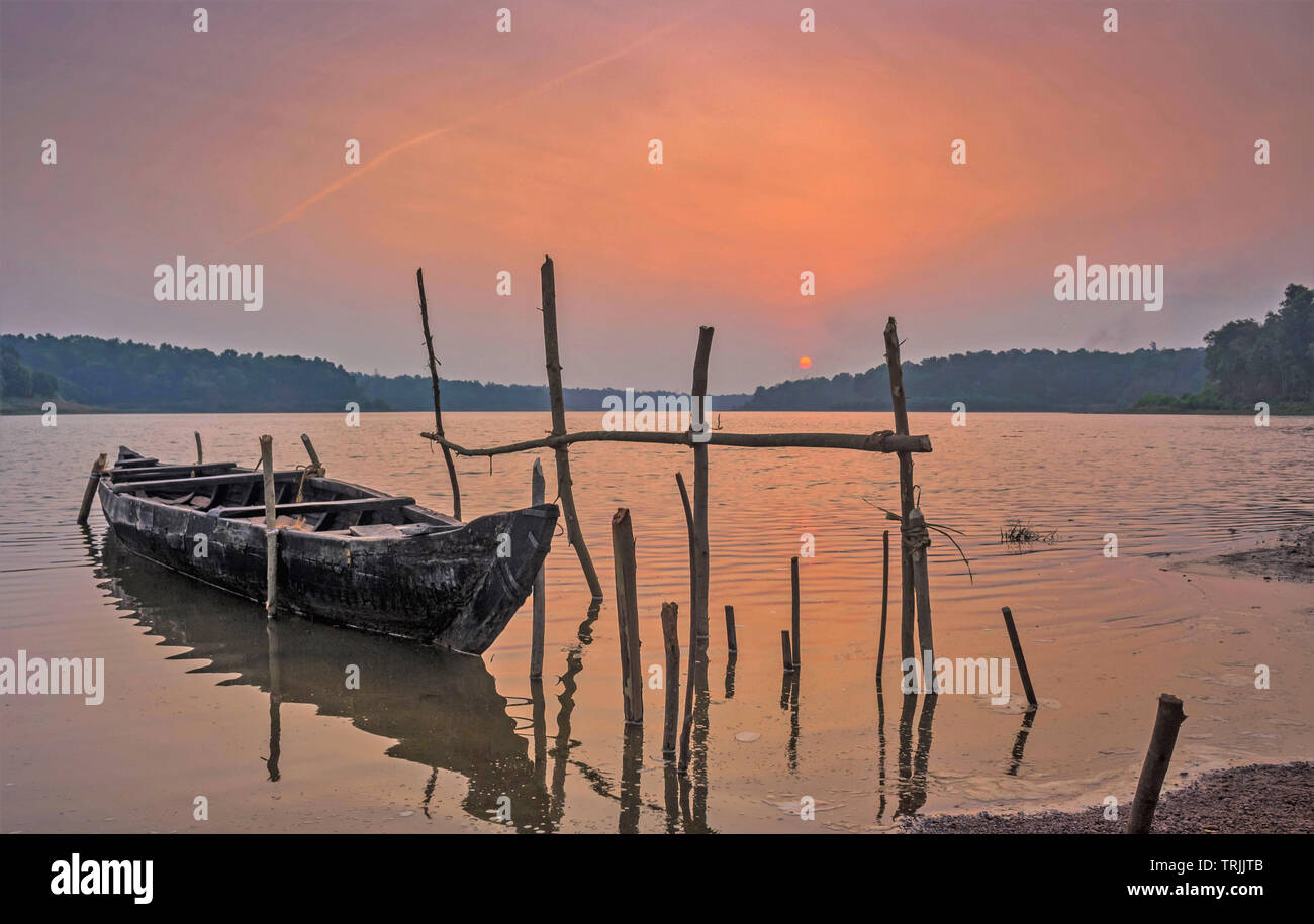 Kerala, India - January 13, 2017: A fishing boat resting on a lake at sunset time, image captured from Sasthamkotta lake, Kerala, India Stock Photo
