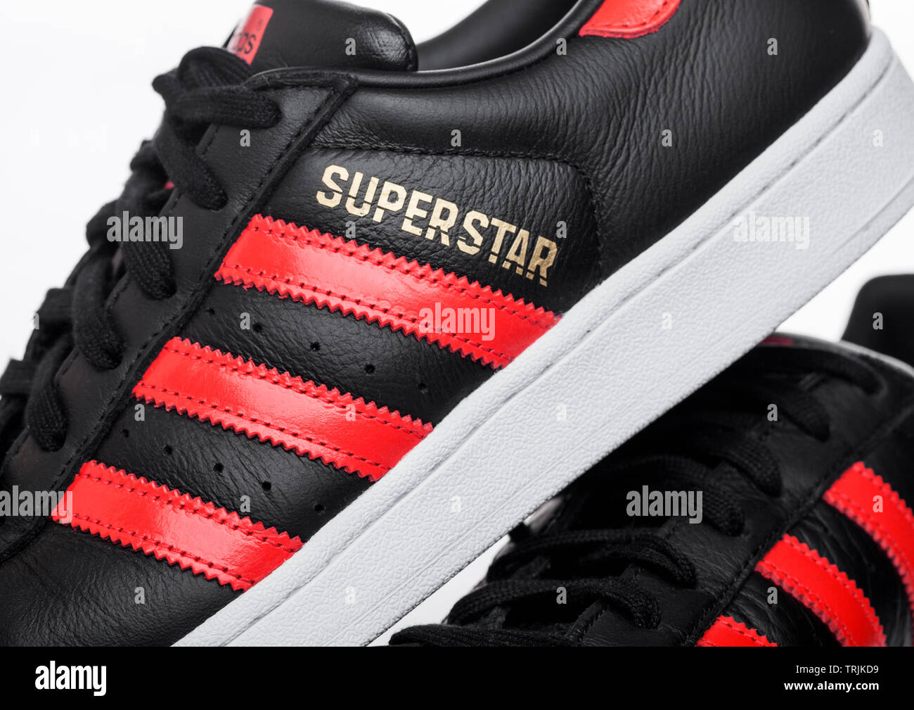 LONDON, UK - JUNE 05, 2019: Adidas Originals Superstar black shoes with red  stripes on white background Stock Photo - Alamy