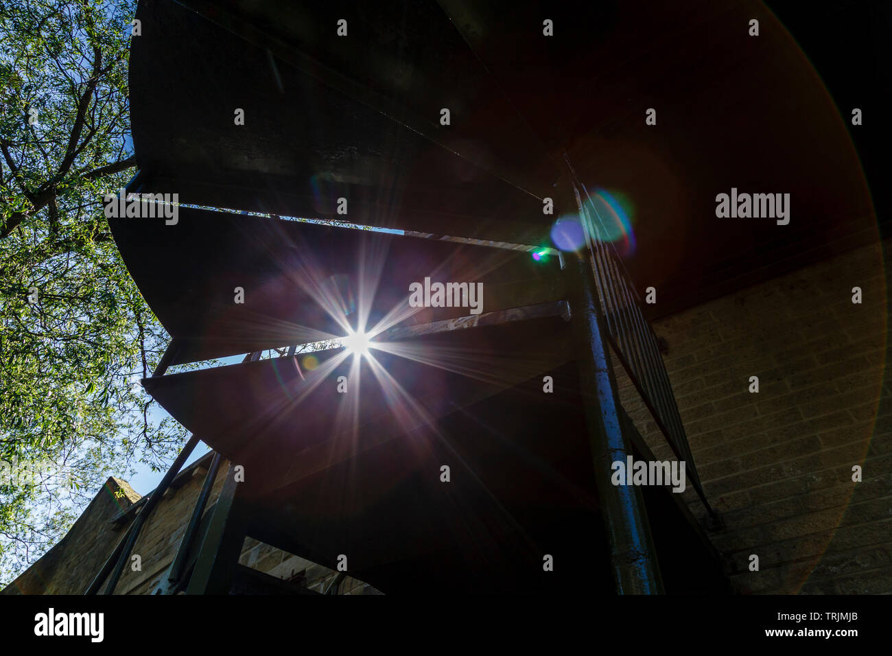 Sun flare created by the sun shining through a gap in a spiral staircase. Stock Photo